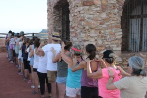 Grupo de participantes realizando una dinámica de conexión y confianza durante un retiro de verano en la Sierra de Mariola, Alicante.